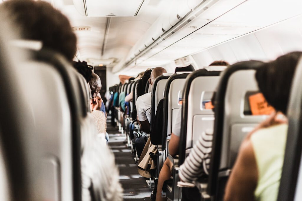 Passengers seated in an airplane cabin aisle, representing companion travel and airline booking