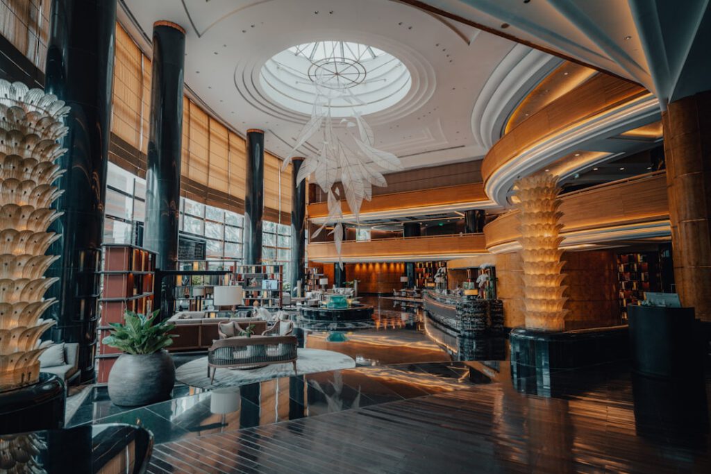 Grand luxury hotel lobby with chandelier and marble floors, illustrating the Chase Sapphire Preferred $100 hotel credit benefit.