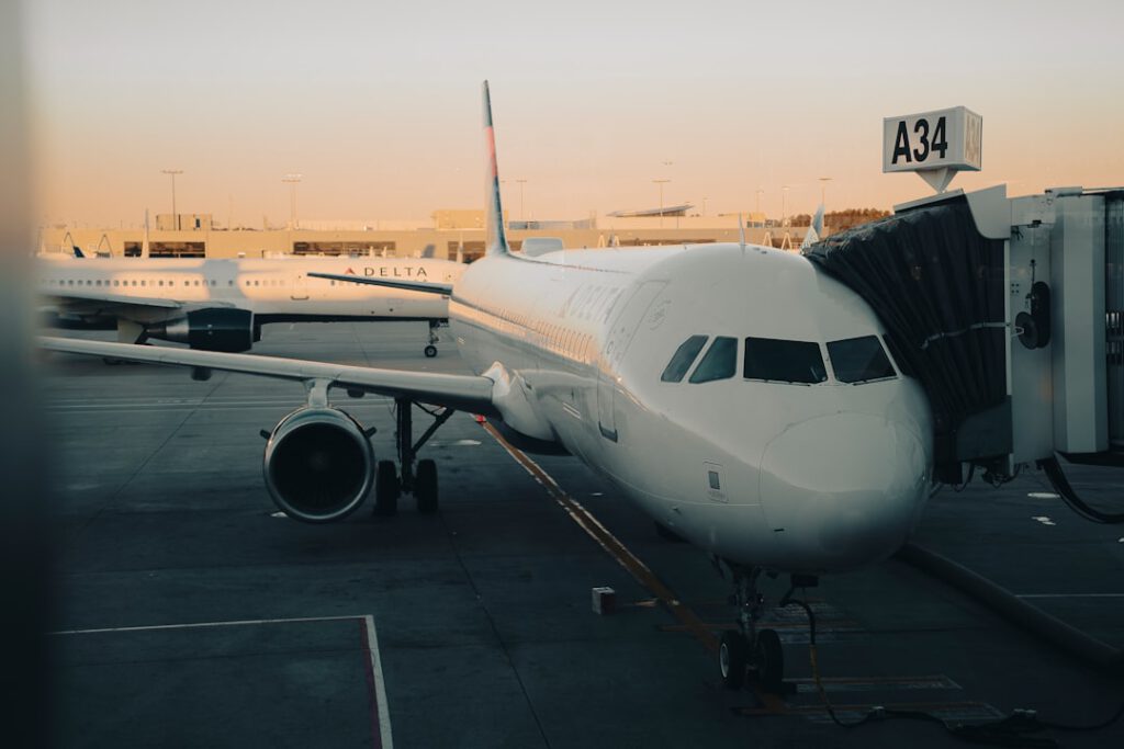 Airplane parked at gate A34 at Hartsfield-Jackson Atlanta International Airport during golden hour, connected to the jet bridge